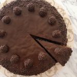 A chocolate truffle cake with one slice cut out
